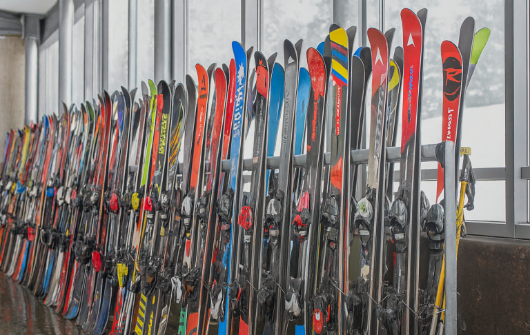 Ett radhus av färgglada skidor i en skidstuga med snöiga fönster.