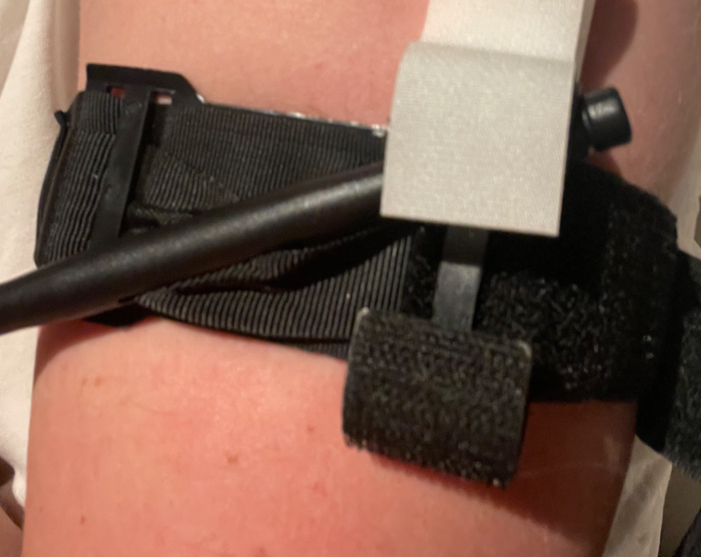 Svart Tourniquet med en svart rem och pinne fast satt på en arm