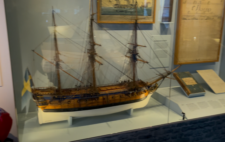 Modell av ett segelfartyg med detaljerad dekoration och svenska flaggan.