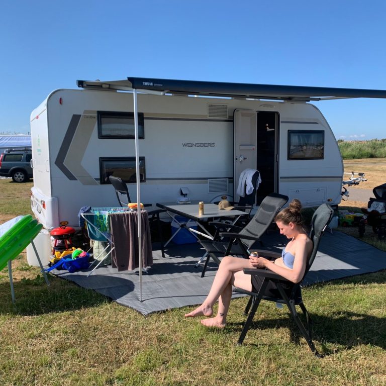 Koppar med öl och vinglas  på ett bord med en snöiga alpbergskuliss i bakgrunden. Fjällen!