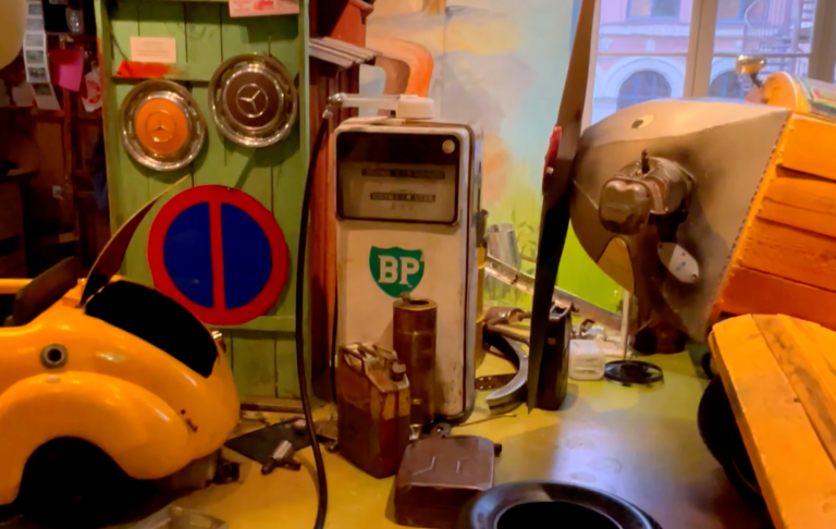 Retro inredning med en gammal bensinpump, leksaksfordon och färgglada detaljer.