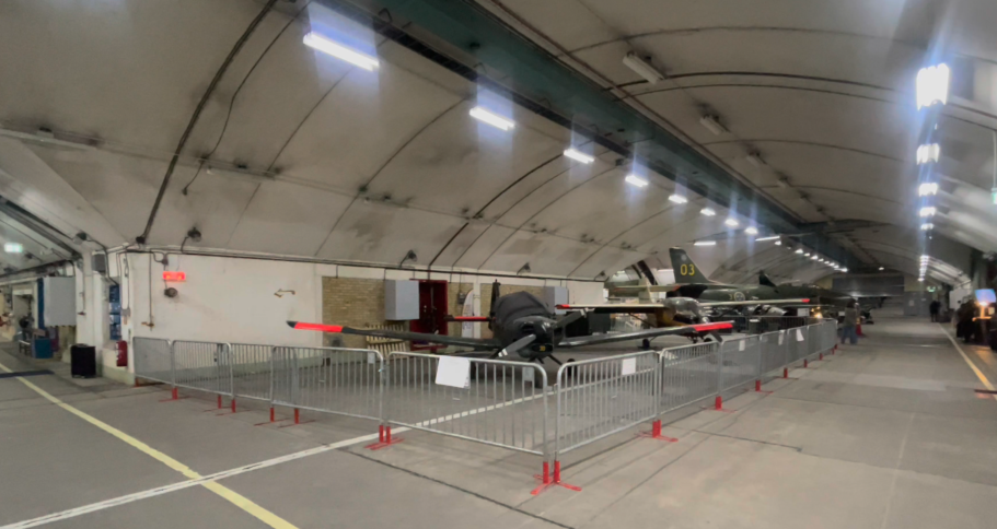 Aeroseum - Nya Berget En stor hangar med flygplan och avspärrningar längs golvet.