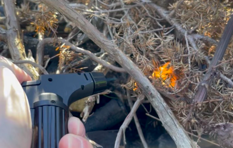 En handhållen brännare används för att tända torrt växtmaterial.
