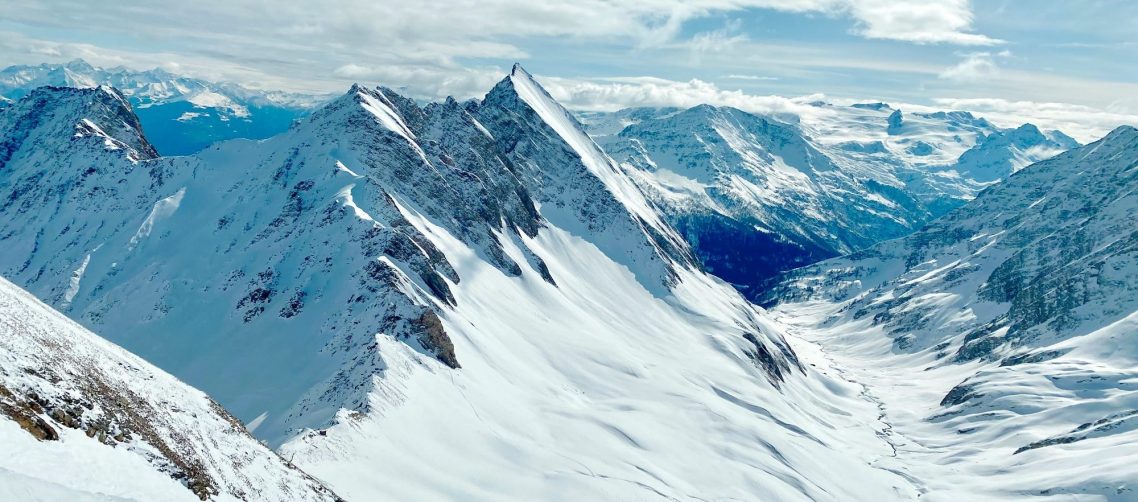 Courmayeur - Italien Snötäckta fjäll i fjärran med en vidsträckt dal mellan dem.