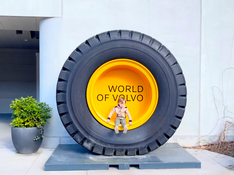 En stor Volvo-däckskonstruktion med texten "WORLD OF VOLVO" och en liten modell sittande i.