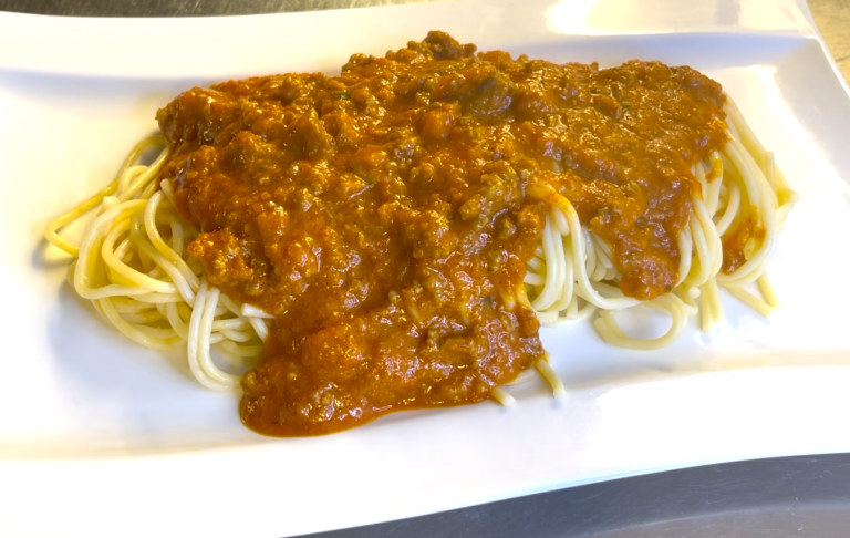 Skelett med hår i monter med en gul påle genom buken.