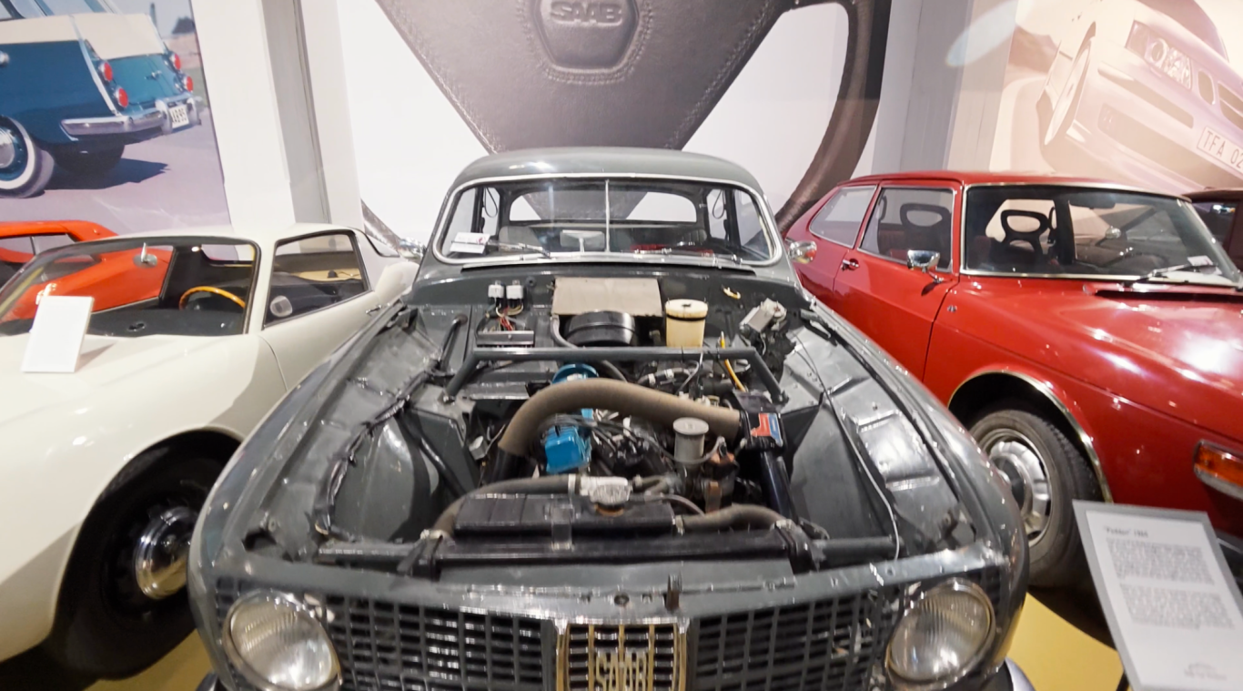 Saab Paddan En gammal bil med öppen motorhuv, omgiven av fler klassiska bilar.